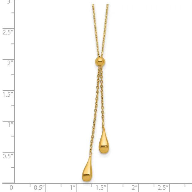 Gold lariat necklace with two teardrop pendants hanging from adjustable chains, displayed against a measurement ruler.