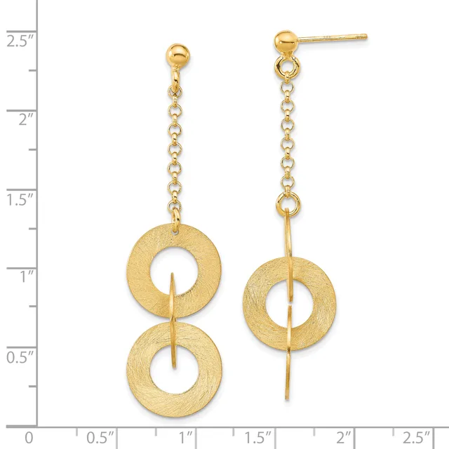 Gold-colored dangle earrings with brushed textured finish featuring two stacked circular rings suspended from a delicate chain, shown against a measurement scale.