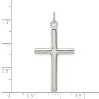A polished silver cross pendant with a rounded top loop, shown next to a ruler indicating its height is approximately 1.5 inches.