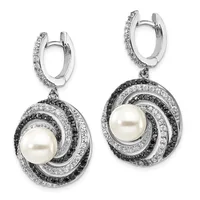 Pair of silver drop earrings with pearl centers surrounded by concentric swirling bands of black and white diamonds, suspended from diamond-set huggie hoops.