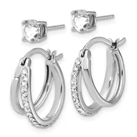 Two pairs of silver stud and hoop earrings: studs feature round clear faceted stones in four-prong settings; hoops have a polished silver finish with pavé-set clear crystals along one side.