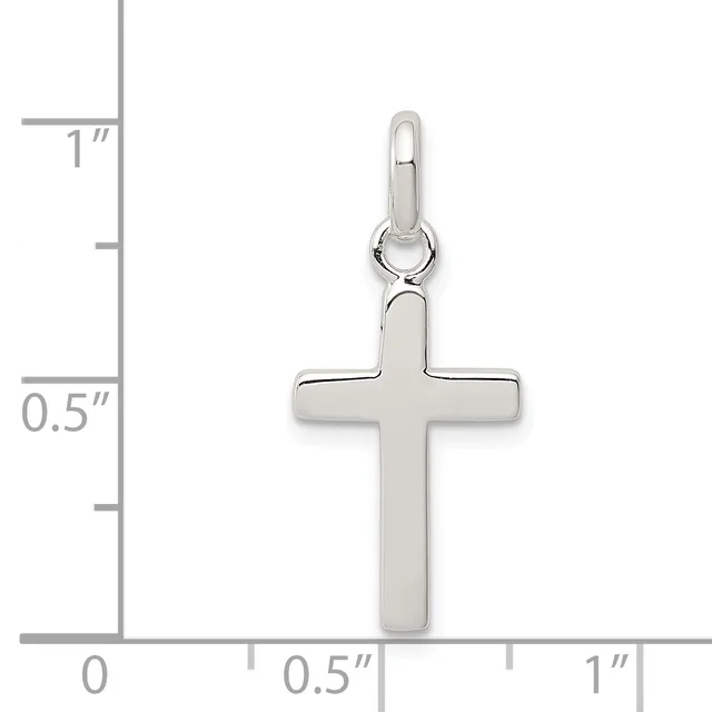 A polished silver cross pendant with a small loop at the top, shown against a ruler indicating approximately one inch in height.