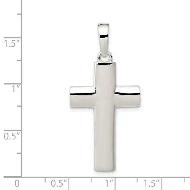 A polished silver cross pendant with rounded edges and a small bail loop at the top, shown with a ruler indicating it measures approximately 1.5 inches in height.