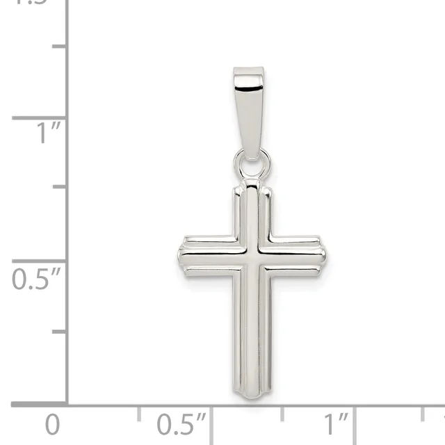 A polished silver cross pendant with a rectangular bail, shown next to a ruler indicating it measures approximately one inch tall and half an inch wide.