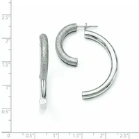 Two silver hoop earrings displayed against a ruler showing measurements up to 2.5 inches: one textured curved post earring and one polished chunky hoop with post back.