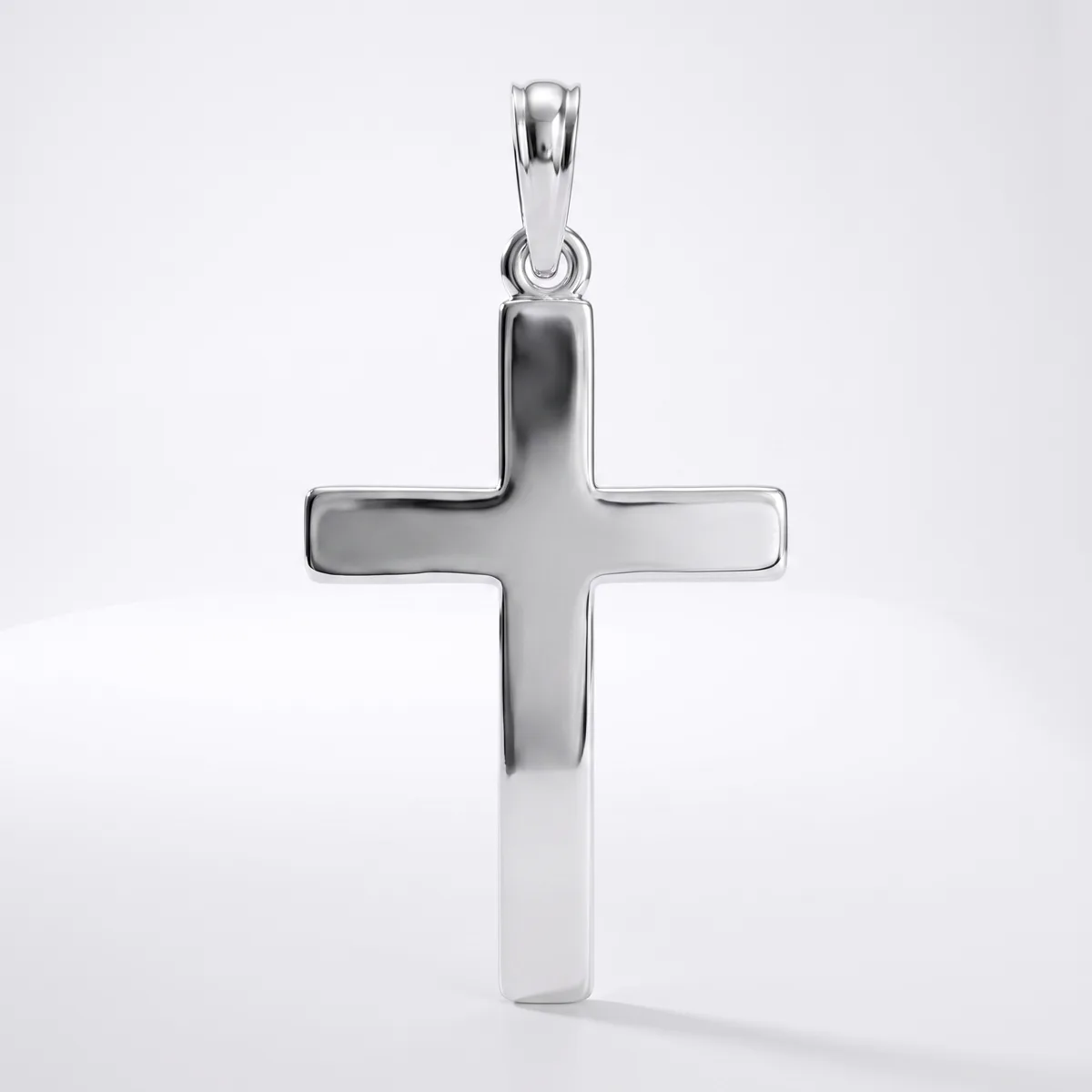 A polished silver cross pendant with a rounded bail, displayed against a white background with a subtle shadow beneath.
