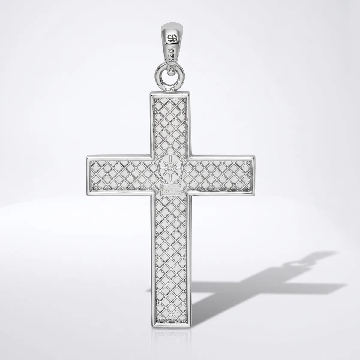 A silver cross pendant with a quilted diamond pattern surface and a small cross motif at its center, shown with its bail and shadow against a white background.