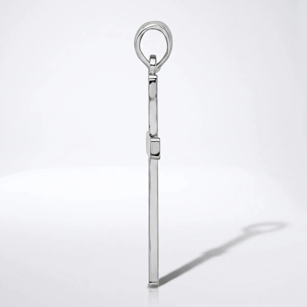A polished metal eye bolt with a long shaft and threaded section, shown vertically against a white background with its shadow visible.