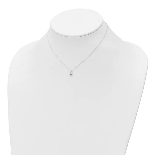 A silver chain necklace with a small pendant featuring a red gemstone displayed on a white mannequin bust.