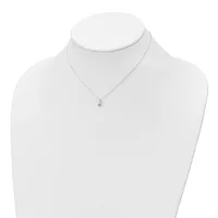 A silver chain necklace with a small pendant featuring a red gemstone displayed on a white mannequin bust.