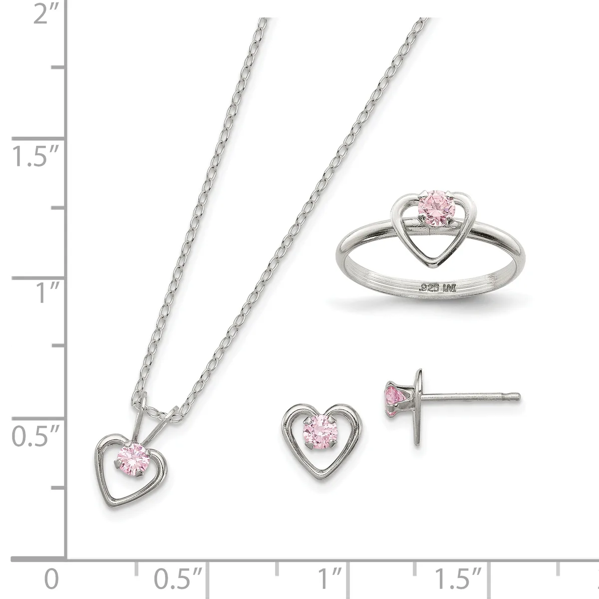 Three sterling silver jewelry pieces with pink cubic zirconia stones arranged on a measurement scale: a heart pendant necklace, matching heart stud earrings, and a heart ring.