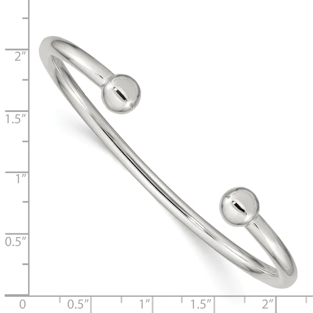 Silver-toned cuff bracelet with spherical ball ends, shown at actual size against a ruler measuring approximately two inches in diameter.