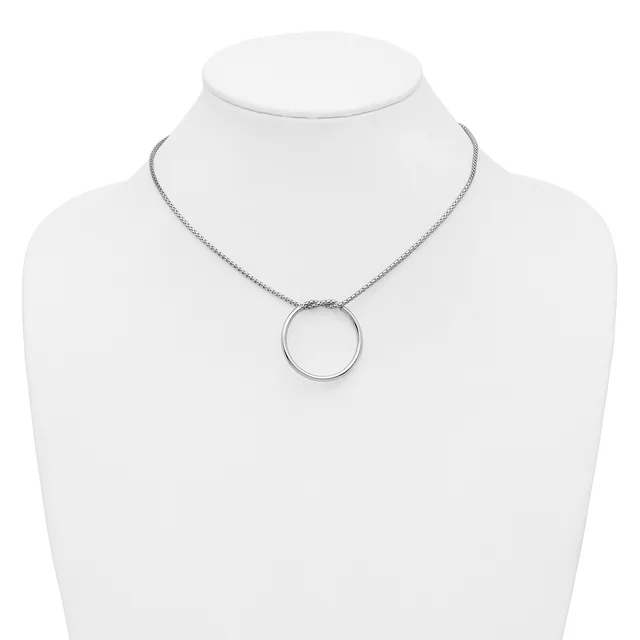 A silver-toned circular pendant necklace displayed on a white mannequin bust.