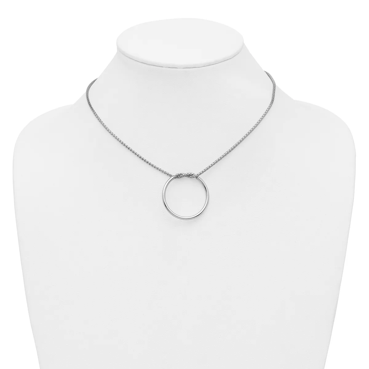 A silver-toned circular pendant necklace displayed on a white mannequin bust.