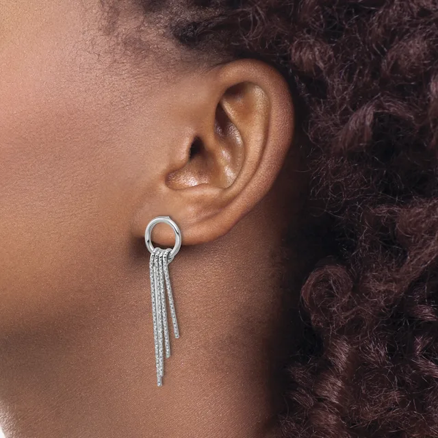 A person wearing a silver hoop earring with dangling tassel chains hanging from the bottom, shown from the side profile view.