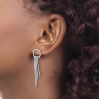 A person wearing a silver hoop earring with dangling tassel chains hanging from the bottom, shown from the side profile view.