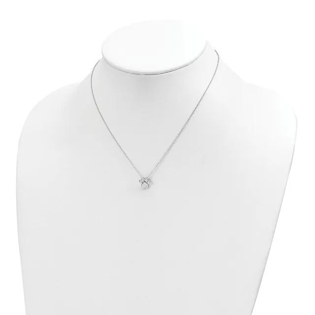 A delicate silver chain necklace with a small diamond solitaire pendant displayed on a white mannequin bust.
