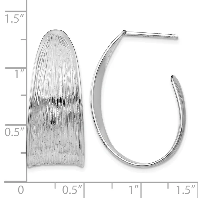 Two silver earrings displayed next to a ruler: a textured oval dome earring and a curved hoop earring, both approximately one inch in length.