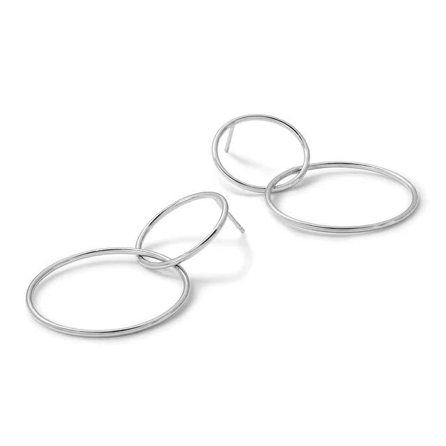 Three silver-toned metal bangle bracelets of varying sizes arranged in a diagonal line on a white background.