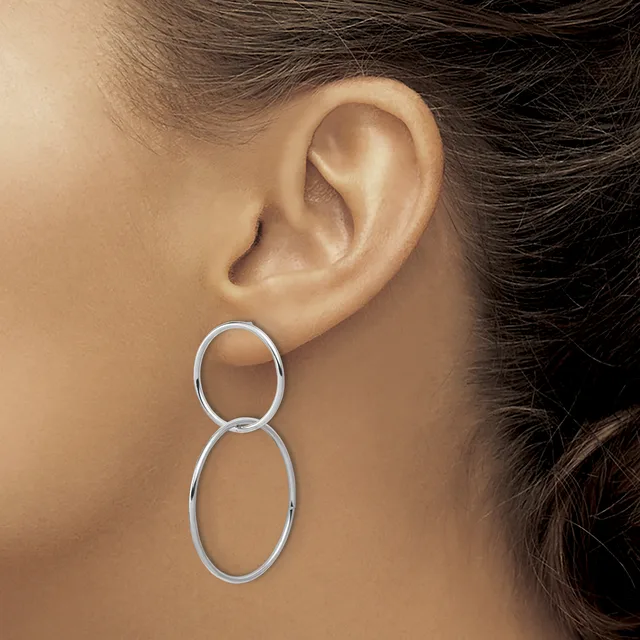 Silver double oval drop earring worn on a person's earlobe, shown from the side profile view.