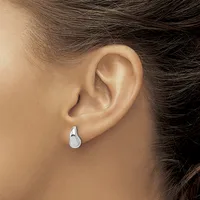 A person wearing a small silver teardrop-shaped earring in their earlobe, shown in profile view.