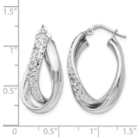 A pair of silver hoop earrings with textured and polished surfaces, displayed next to a ruler showing they measure approximately one inch in length.