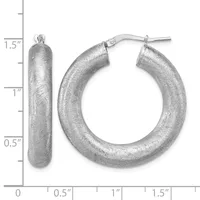 A pair of textured silver hoop earrings with a brushed finish, displayed next to a ruler showing they measure approximately 1.5 inches in length.