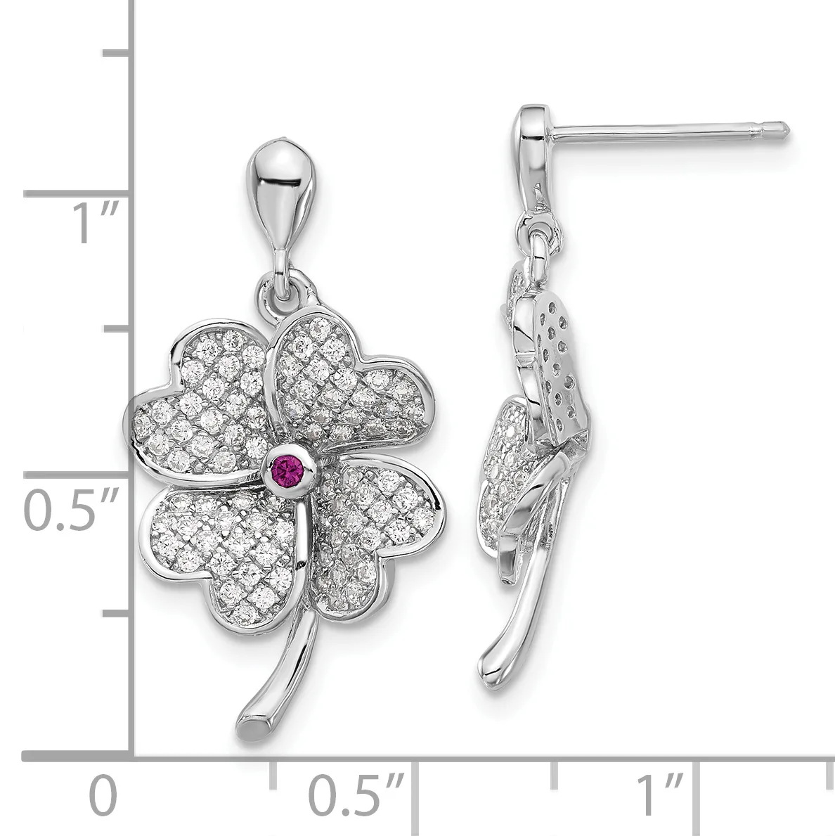 Silver four-leaf clover pendant earrings with cubic zirconia stones and a small pink ruby center stone, shown on a measurement scale.