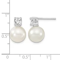A pair of silver stud earrings with round white pearls suspended below round diamond-shaped crystal stones, displayed next to a measurement ruler.