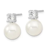 A pair of silver stud earrings featuring round white pearls suspended below cushion-cut diamond studs.