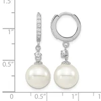 A pair of silver hoop earrings with diamond-accented posts and white pearl drops, displayed next to a measurement scale.