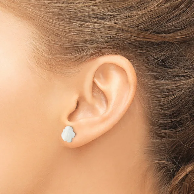 A person wearing a small white flower-shaped stud earring in their earlobe, shown in profile.