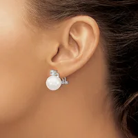 A woman wearing a silver earring with a white pearl and small rectangular stone stud, shown from the side view near her ear.