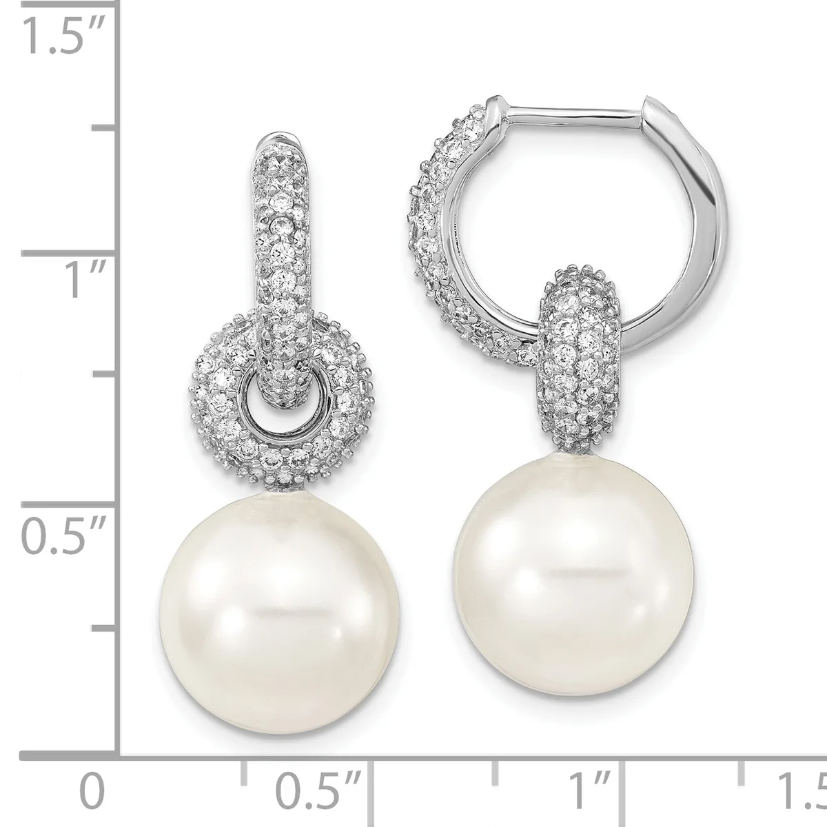 A pair of silver hoop earrings with cubic zirconia-paved dome tops and dangling white pearl drops, displayed on a measurement scale.