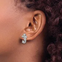 A silver seahorse-shaped earring worn on a person's earlobe, featuring a polished finish and small stamped hallmark.