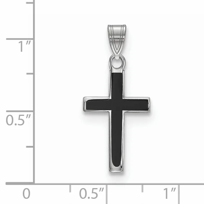 A silver cross pendant with black enamel inlay shown against a ruler measuring approximately one inch tall by half an inch wide.