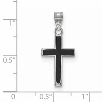 A silver cross pendant with black enamel inlay shown against a ruler measuring approximately one inch tall by half an inch wide.