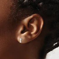 A small rectangular silver earring worn in a pierced earlobe, shown from the side on a person with brown skin and dark hair.
