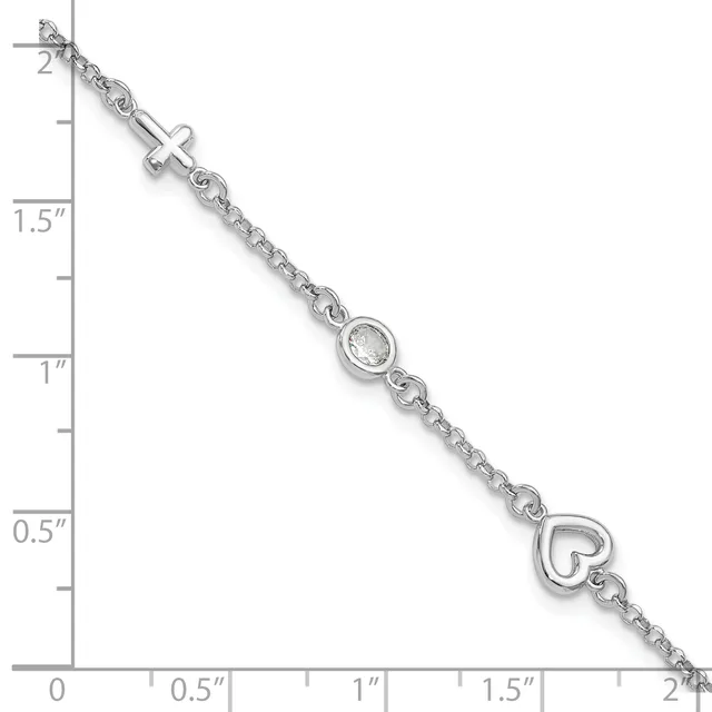 Silver bracelet with a cross charm, a cubic zirconia stone, and a heart charm, displayed against a measurement scale showing approximately two inches in length.