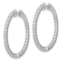 A pair of oval diamond hoop earrings in white metal with round brilliant diamonds set along the entire outer surface, shown from the front at slightly different angles.