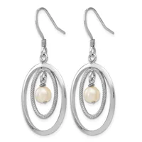 A pair of silver dangle earrings with nested oval frames, each suspending a cream-colored pearl from a textured inner oval, hanging from silver ear wires.