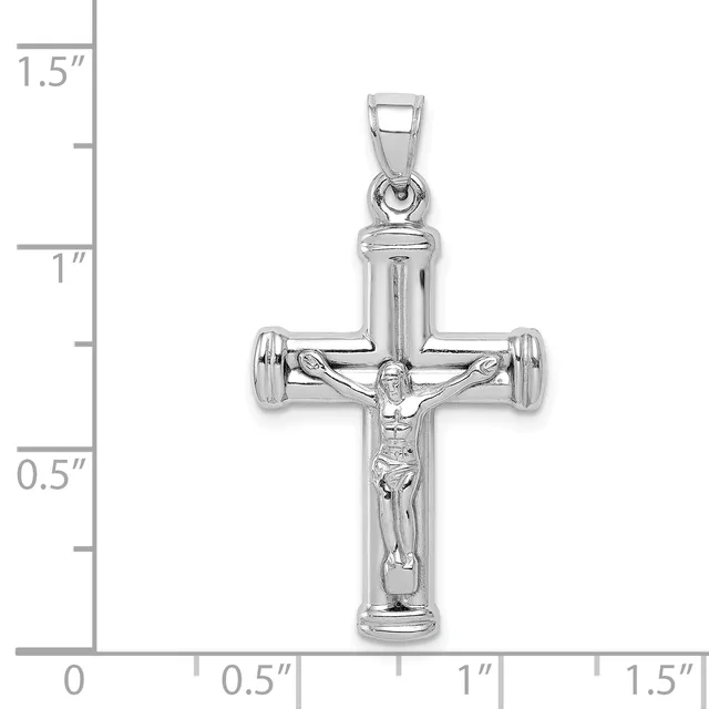 A silver crucifix pendant with a polished finish and detailed corpus figure, shown against a measurement scale indicating approximately 1.25 inches in height.