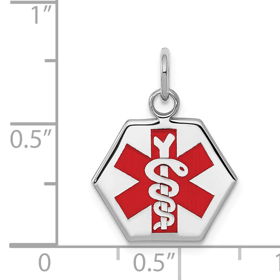 Hexagonal silver medical alert pendant with red and white enamel star of life symbol, shown against a ruler indicating approximately one inch in height.