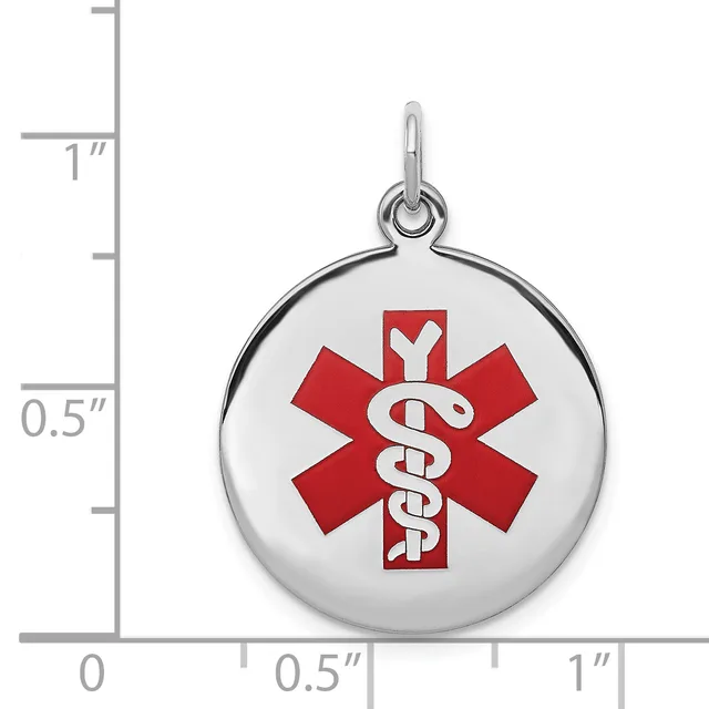 Round silver medical alert pendant with red star of life symbol and white staff, shown next to a ruler measuring approximately one inch in diameter.
