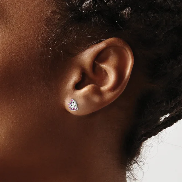 A person wearing a small teardrop-shaped stud earring with a purple or lavender stone set in what appears to be silver or white metal.