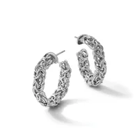 A pair of ornate silver hoop earrings with intricate braided and twisted textures throughout, displayed against a white background.