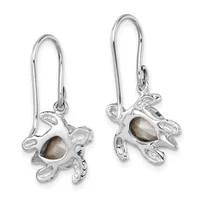 A pair of silver earrings with long curved hooks, each featuring a small silver octopus charm with a gray-brown stone set in its center.