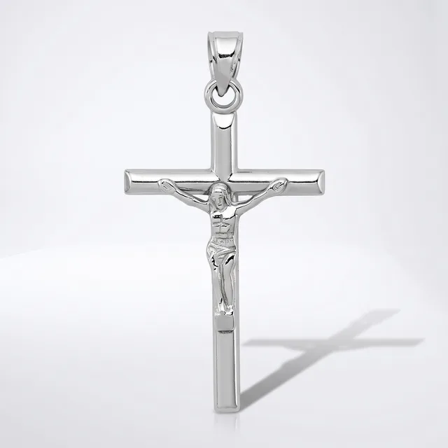 A silver crucifix pendant with a polished finish, featuring a detailed corpus figure, shown against a white background with a shadow visible to the right.