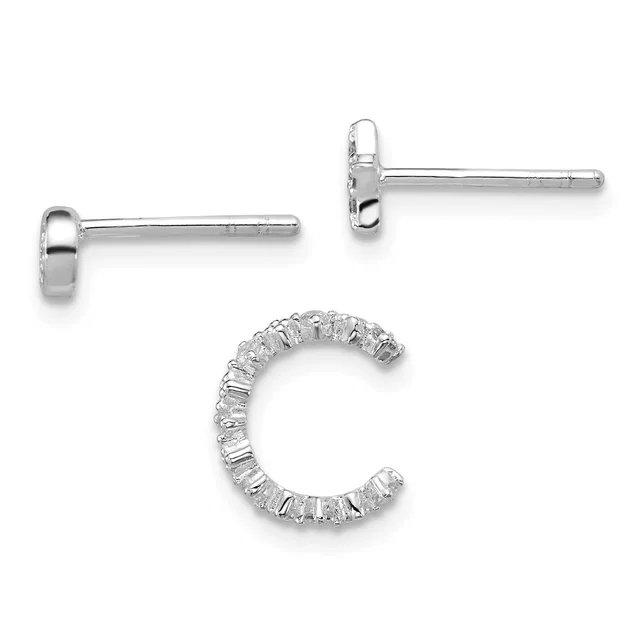 Three pieces of silver jewelry displayed: two simple stud earrings with polished posts and backs, and one open hoop earring with a textured surface featuring rectangular stone settings.