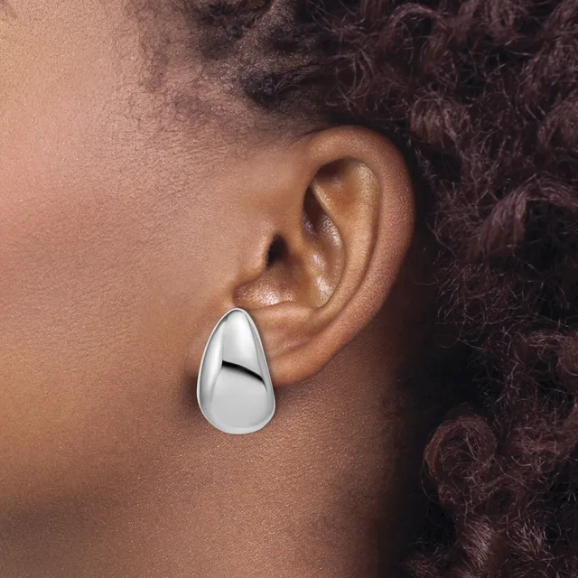 A polished silver teardrop-shaped earring worn on a person's earlobe, shown in profile view against their neck and shoulder.